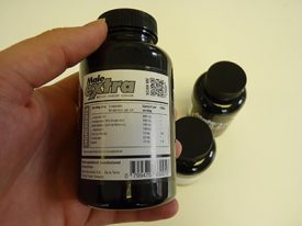 Maleextra bottle with ingredients being shown in left hand