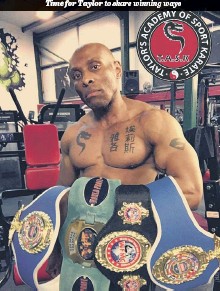 Robert Taylor kickboxing champion holding belts