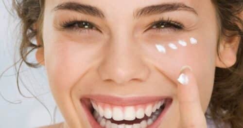 Smiling woman applies XYZ smart collagen to her face